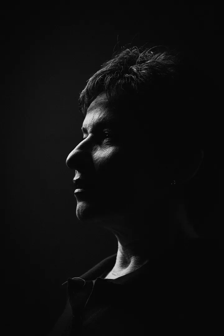 Perfil de uma pessoa em preto e branco, apenas o rosto recortado pela luz.